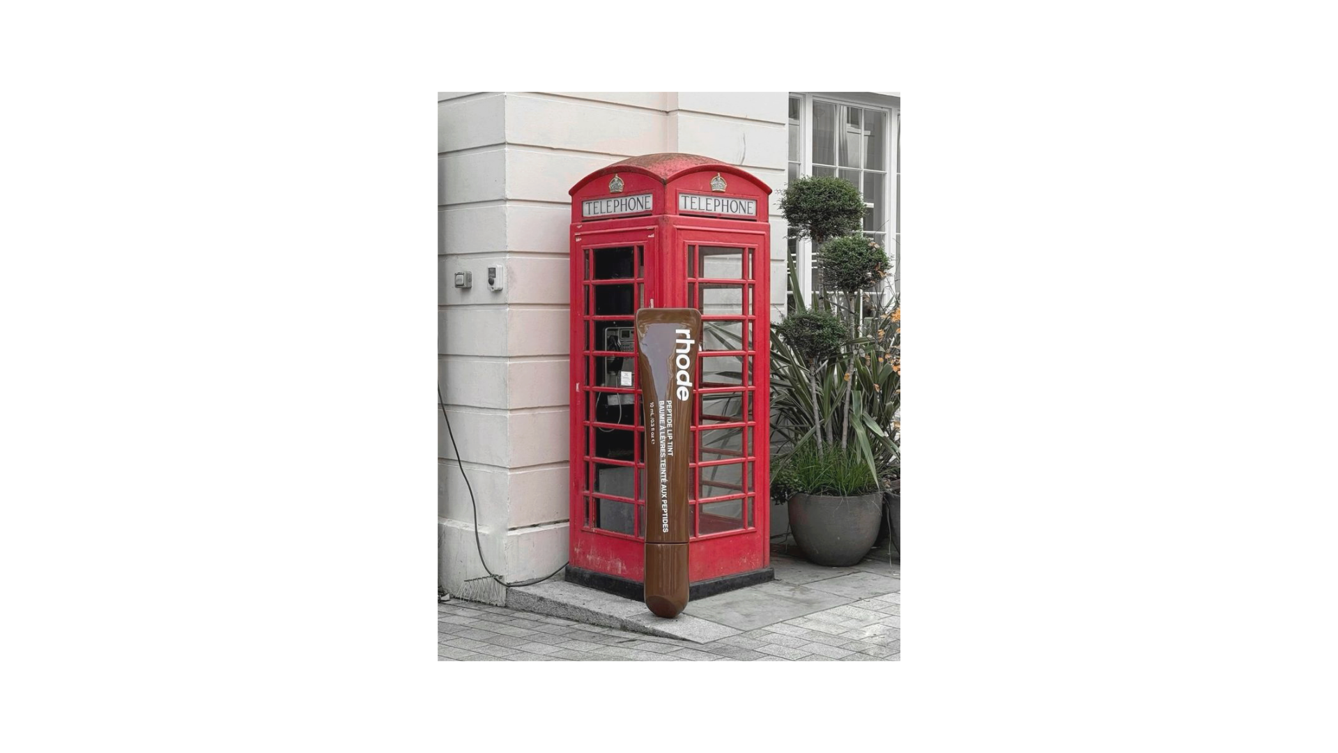 Red London phone booth wrapped as a rhode activation — the brand's first IRL UK touchpoint